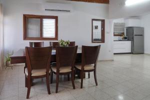 a dining room table with chairs and a kitchen at שלווה במושבה מגדל - וילה מדהימה עם בריכה פרטית וג'קוזי ליד הכנרת in Migdal +20 photos