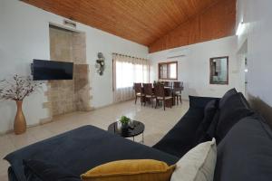 a living room with a blue couch and a table at שלווה במושבה מגדל - וילה מדהימה עם בריכה פרטית וג'קוזי ליד הכנרת in Migdal