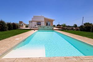 a swimming pool in front of a house at Villa Brezza dello Ionio in Marina di Pescoluse