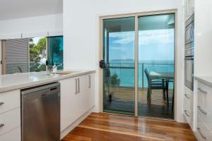 a kitchen with a view of the ocean at Heaven at Denhams in Denhams Beach