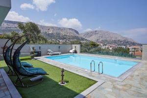 ein Schwimmbecken mit zwei daneben stehenden Liegestühlen in der Unterkunft Poolside at Vrontados in Vrontádos