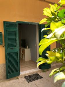 a green door leading to a room with a table at Appartamento I Canali in Rio nellʼElba