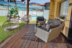 a porch with chairs and swings on a deck at שלווה במושבה מגדל - וילה מדהימה עם בריכה פרטית וג'קוזי ליד הכנרת in Migdal