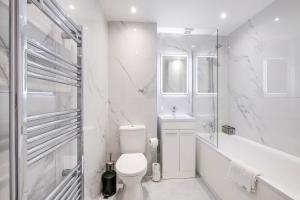 a white bathroom with a toilet and a sink at Modern 2 Bedroom Apartments Town Centre Camberley in Camberley +52 photos