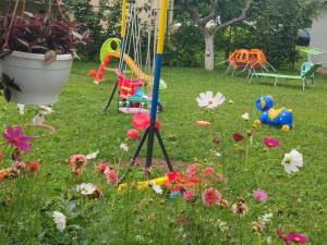 ein Garten mit Spielplatz und Blumen im Rasen in der Unterkunft Uma in Bihać + 23 Fotos