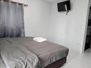 een bed met een handdoek op een kamer bij Layla Garden resort in Ban Hua Na