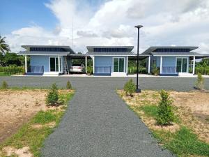 een blauw huis met een auto op de oprit bij Layla Garden resort in Ban Hua Na