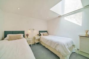a bedroom with two beds and a window at N ° 42 The Salcombe in Salcombe +25 photos