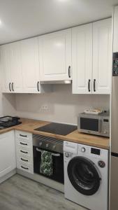 eine Küche mit Waschmaschine und Mikrowelle in der Unterkunft Marina Golden Choice - Piso nuevo a 350m playa in Oropesa del Mar