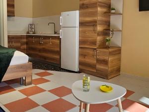 a kitchen with a white refrigerator and a table at Lemon House Borsh in Himare
