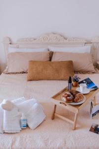 a bed with a table with a plate of food on it at Casa Ferrari Vista Mare in Formia
