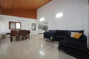 a living room with a black couch and a table at שלווה במושבה מגדל - וילה מדהימה עם בריכה פרטית וג'קוזי ליד הכנרת in Migdal