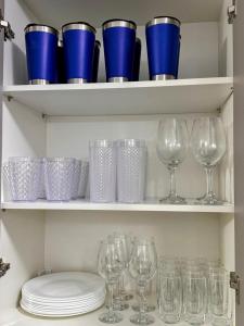 a bunch of wine glasses and plates on shelves at Apartamento Vista Mar 71 in Praia Grande