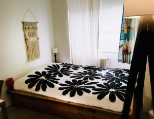 a bedroom with a bed with a black and white blanket at Chambre ville & campagne in Nantes