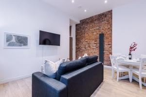 a living room with a black couch and a brick wall at Modern 2-bedroom Apt In The Heart Of City Centre in Liverpool
