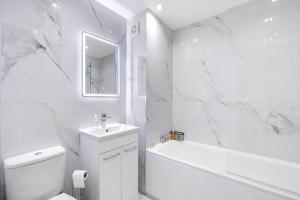 a white bathroom with a tub and a toilet and a sink at Modern 2 Bedrooms Apartment 01 Town Centre Camberley in Camberley +33 photos