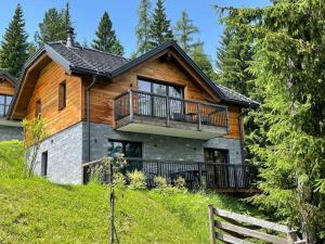 drewniany dom z balkonem na wzgórzu w obiekcie Tomtegl-Bergchalet-No-7-mit-Privatsauna-Infinitypool-Kamin-Fitnessraum-1500m-Seehoehe w mieście Hochrindl
