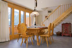 a dining room with a wooden table and chairs at Chalet Bella Vista 12 - Penthouse in Wengen
