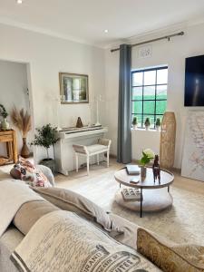 una sala de estar con un sofá y una mesa en Sage Serenity Retreat, en Ciudad del Cabo