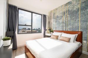 a bedroom with a large bed and a window at Otis Soho Saigon Balcony Apartment in Ho Chi Minh City