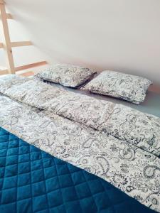 a bed with two pillows on top of it at Domek Pocieszna Podkowa in Rabka-Zdroj