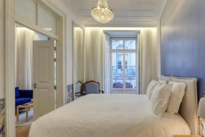 a bedroom with a large white bed and a window at Boutique Chiado Suites in Lisbon