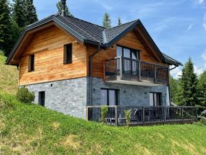 ein Haus auf einem Hügel mit Balkon in der Unterkunft Tomtegl-Bergchalet 9 mit Privatsauna, beheiztem Infinitypool, Kamin, Fitnessraum, auf 1500m Seehöhe  in Hochrindl