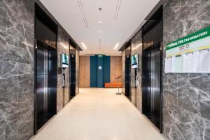 a hallway of elevators in an office building at Otis Soho Saigon Balcony Apartment in Ho Chi Minh City