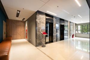 a lobby with a red chair in the middle of a room at Otis Soho Saigon Balcony Apartment in Ho Chi Minh City