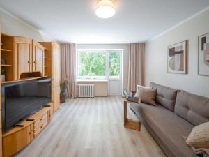 a living room with a couch and a television at City Park Quiet Residence - 2 Room Apartment with Balcony & View in Jūrmala +25 photos