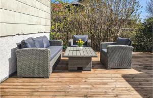 three wicker chairs and a table on a patio at Lovely Apartment In Öland With Wifi in Degerhamn