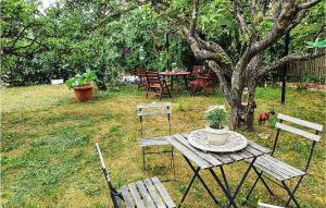 a picnic table and chairs in a yard with a tree at Lovely Apartment In Öland With Wifi in Degerhamn