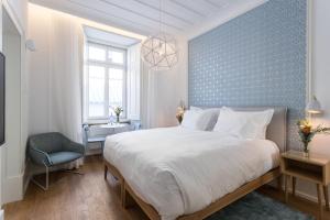 a bedroom with a large bed and a blue wall at Boutique Chiado Suites in Lisbon