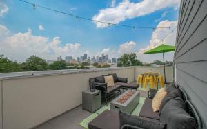 d'une terrasse avec un canapé et des chaises sur un balcon. dans l'établissement 3bd-Rooftop Movie Theater-BBQ-Retro Music Theme-Downtown 8mins, à Houston