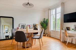 Un comedor con una mesa y sillas y un espejo. en Modern Design 1 BR near Parc des Princes, en Boulogne-Billancourt
