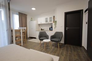 a small room with two chairs and a kitchen at Adagio Apartmani in Vrnjačka Banja