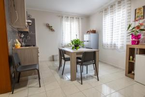 una cucina con tavolo, sedie e frigorifero di Casa Josy a Francavilla di Sicilia