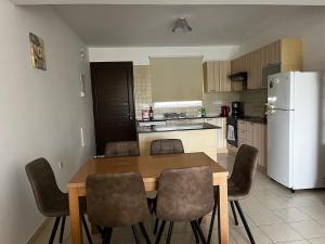 a kitchen with a table and chairs and a white refrigerator at Hana Nissi in Ayia Napa