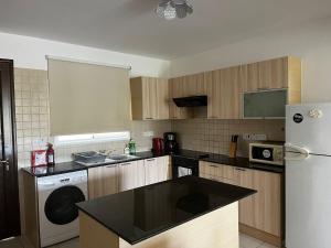 a kitchen with a refrigerator and a washer and dryer at Hana Nissi in Ayia Napa +4 photos