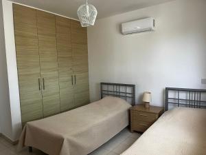 a bedroom with two beds and a dresser at Hana Nissi in Ayia Napa