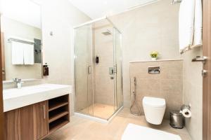 un bagno con doccia, WC e lavandino di Kyriad Muscat a Mascate