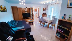a living room with a blue couch and a table at Apartment Wine & Olive oil Mofardin in Koper