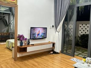 a living room with a flat screen tv on a table at Á Châu homestay in Ấp Thanh Sơn (1)