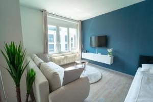 a living room with a couch and a tv at RANGE - Apartments - Küche - WLAN - Netflix - 1-7 Personen in Fellbach