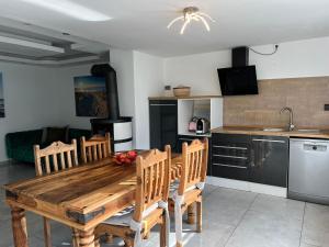 a kitchen with a wooden table and wooden chairs at Moderne Ferienwohnung in Dilsberg in Neckargemünd