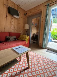 a living room with a red couch and a table at La Wodapalousa, Surf & Crossfit Guesthouse, 800m from Beach in Bidart