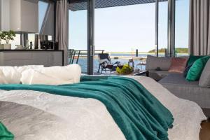 a bedroom with a bed with a green blanket on it at Domy Na Wodzie 3Miasto in Gdańsk