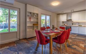 kuchnia z drewnianym stołem i czerwonymi krzesłami w obiekcie Pet Friendly Apartment In Madulin w Medulinie