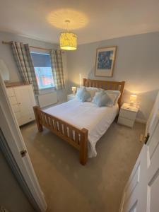 a bedroom with a bed with white sheets and pillows at Newquay Fistral Holiday home with hot tub in Newquay