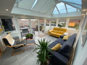 a living room with a blue couch and chairs at Newquay Fistral Holiday home with hot tub in Newquay